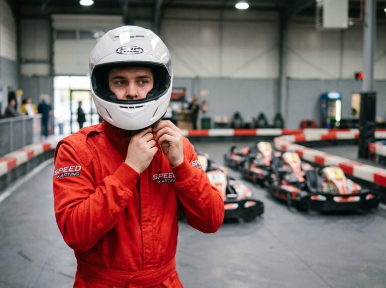 Pilote de karting vérifiant la sangle de son casque avant de monter en kart dans un circuit indoor